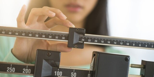 Woman adjusts weight scale