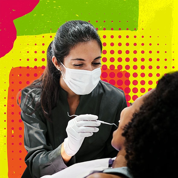 Young female dentist in a face mask using a metal tool to examine a female patient's teeth