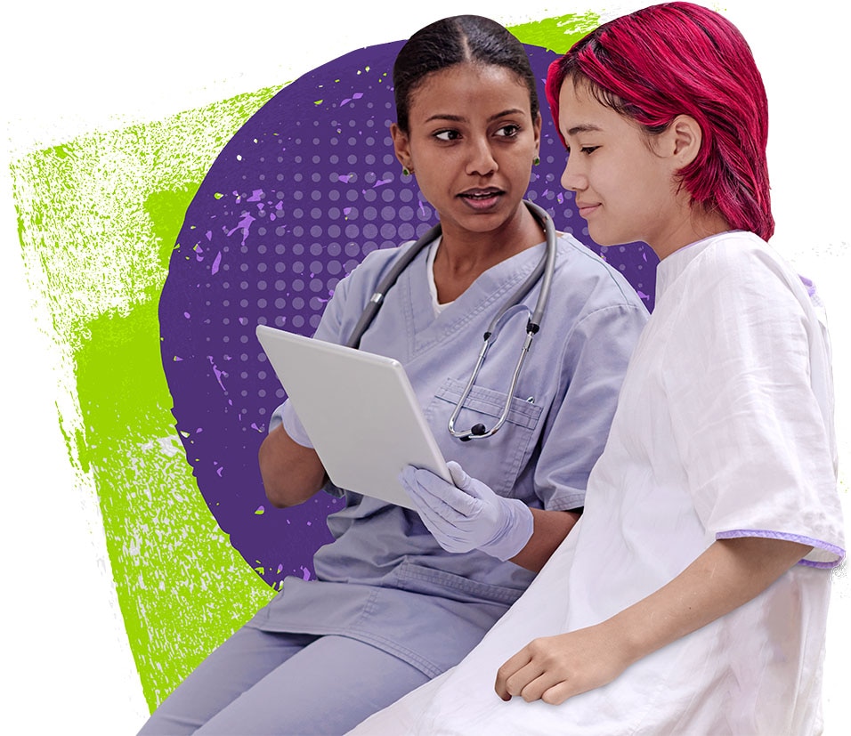 Young female doctor sitting and explaining results on a tablet to a young female patient in a hospital gown