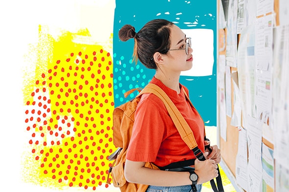 Young female wearing a backpack looking at the bulletin board.