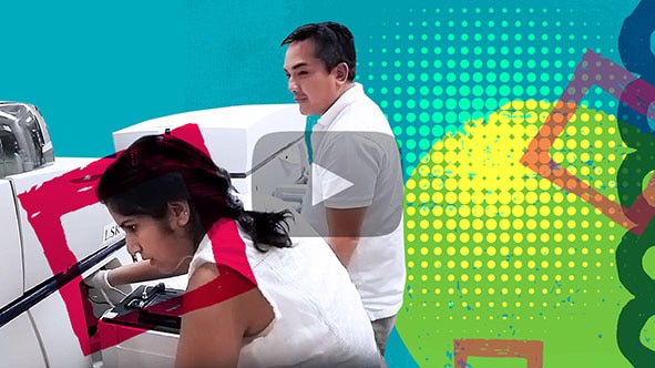 Video thumbnail featuring young woman inputting a code and reaching her hand into a medical lab machine while a young man watches her. Click to open video in popup.